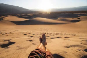 Hombre en desierto con viento refrescante al amanecer