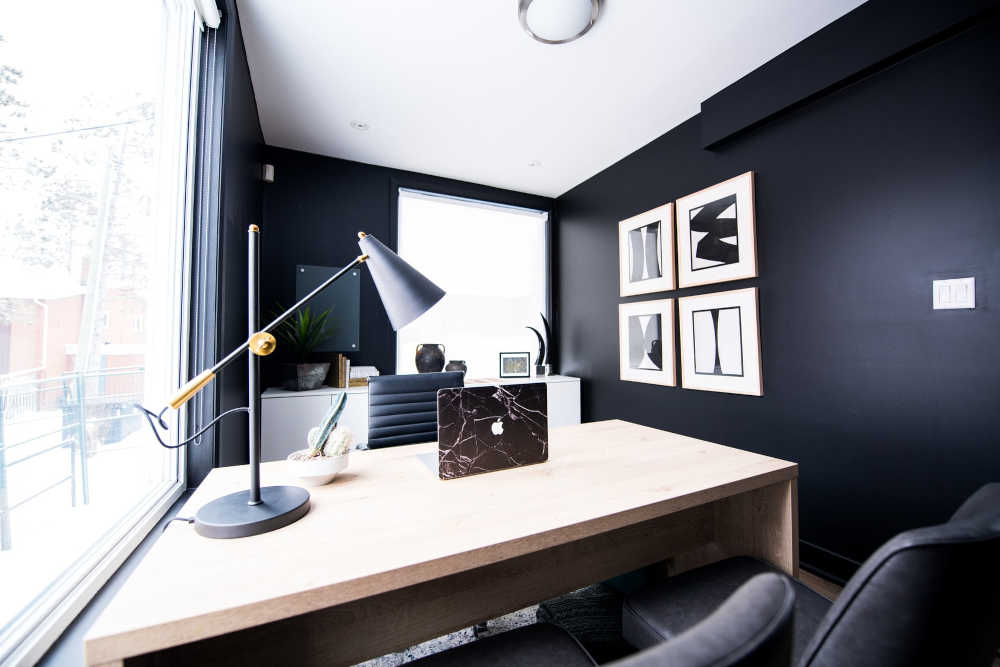 oficina en color negro realza el tapiz y el escritorio blanco